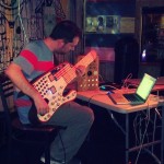 Some kind of synth guitar made from a giant popsicle stick